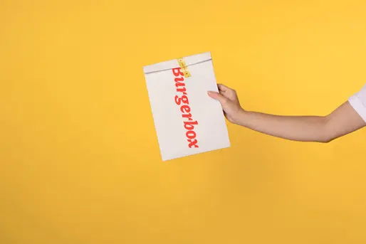 packaging Design a man holding a burgerbox company package